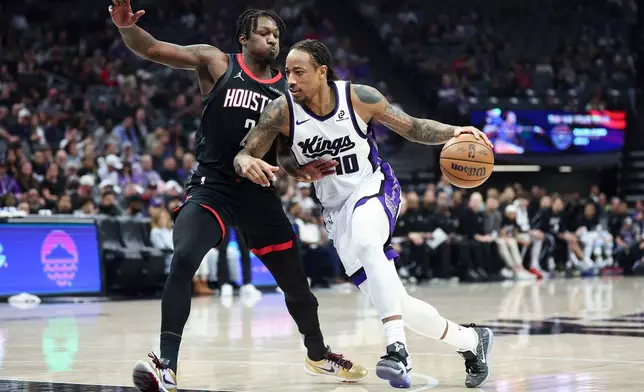 Sacramento Kings guard DeMar DeRozan (10) drives to the basket with Houston Rockets forward Dorian Finney-Smith, left, defending during the first half of an NBA basketball game, Sunday, Jan. 11, 2026, in Sacramento, Calif. (AP Photo/Sara Nevis)