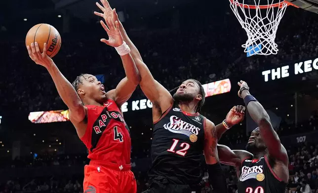 Toronto Raptors forward Scottie Barnes (4) drives to the net as Philadelphia 76ers guard/forward Trendon Watford (12) and Adem Bona (30) defend during first-half NBA basketball game action in Toronto, Sunday, Jan. 11, 2026. (Frank Gunn/The Canadian Press via AP)