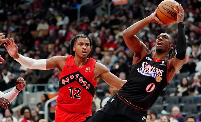 Philadelphia 76ers guard Tyrese Maxey (0) looks to shoot as Toronto Raptors forward Collin Murray-Boyles (12) watches during second-half NBA basketball game action in Toronto, Sunday, Jan. 11, 2026. (Frank Gunn/The Canadian Press via AP)