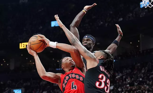 Toronto Raptors forward/guard Scottie Barnes (4) is fouled on his way to the hoop by Philadelphia 76ers forward Jabari Walker (33) as 76ers' Adem Bona, top, looks on during first-half NBA basketball game action in Toronto, Sunday, Jan. 11, 2026. (Frank Gunn/The Canadian Press via AP)