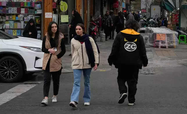 People cross an intersection in downtown Tehran, Iran, Thursday, Jan. 15, 2026. (AP Photo/Vahid Salemi)