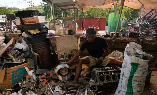 Ivan Vegas separates discarded objects of aluminum and iron to sell by weight in Guatire, Venezuela, Friday, Jan. 9, 2026. (AP Photo/Matias Delacroix)