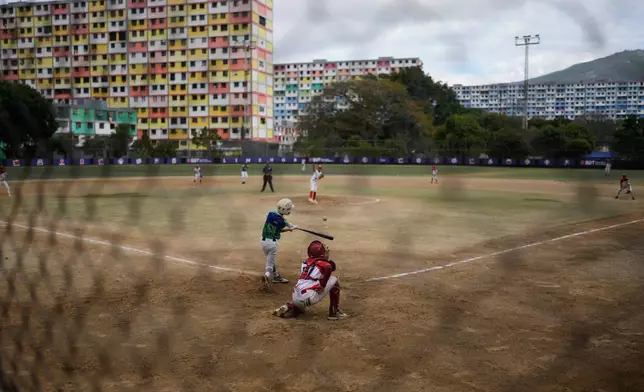 Children play baseball at the 23 de Enero neighborhood in Caracas, Venezuela, Saturday, Jan. 10, 2026, a week after U.S. forces captured Venezuelan President Nicolas Maduro. (AP Photo/Matias Delacroix)