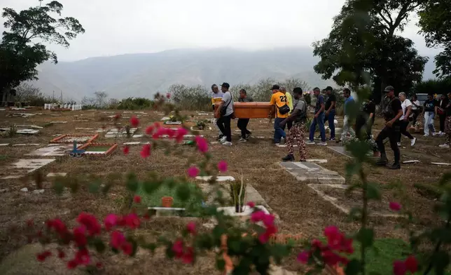 Relatives carry the coffin of Rosa Elena Gonzalez, 80, who died after her apartment was hit during a U.S. strike to capture President Nicolas Maduro, at the cemetery in La Guaira, Venezuela, Monday, Jan. 5, 2026. (AP Photo/Matias Delacroix)