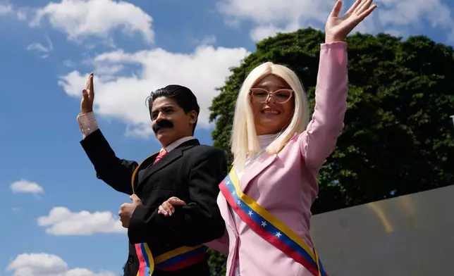 Performers on stilts dressed as former Venezuelan President Nicolas Maduro and his wife Cilia Flores wave during a march by government supporters calling for their release after U.S. forces captured them, in Caracas, Venezuela, Friday, Jan. 9, 2026. (AP Photo/Ariana Cubillos)