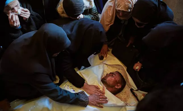 Palestinians attend the funeral of Ahmed al-Qudra at Nasser Hospital in Khan Younis, Gaza Strip, after he was killed in an Israeli military strike, Tuesday, Jan. 6, 2026. (AP Photo/Abdel Kareem Hana)