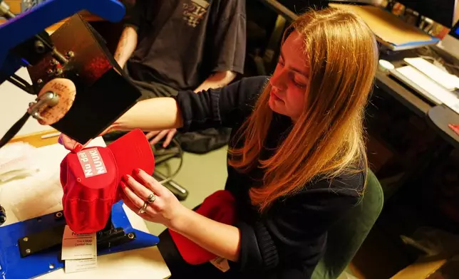 A worker prints red caps for sale covered by the slogan "Nu det NUUK!," a twist on the Danish phrase “Nu det nok,” meaning “Now it’s enough,” substituting Nuuk, Greenland’s tiny capital, a the store of the hat's creator Jesper Rabe Tonnesen in Copenhagen, Denmark, Friday, Jan. 16, 2026. (AP Photo/James Brooks)
