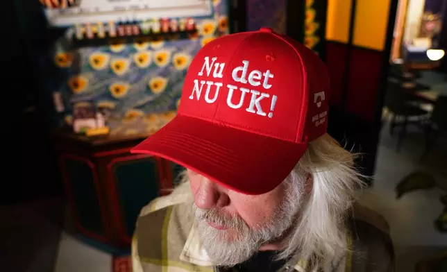Store owner Jesper Rabe Tonnesen wears a red cap for sale that he created with the slogan "Nu det NUUK!," a twist on the Danish phrase “Nu det nok,” meaning “Now it’s enough,” substituting Nuuk, Greenland’s tiny capital, in Copenhagen, Denmark, Thursday, Jan. 15, 2026. (AP Photo/James Brooks)