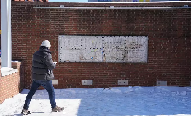 A person moves to photograph the location of the now removed explanatory panels that were part of an exhibit on slavery at President's House Site in Philadelphia, Friday, Jan. 30, 2026. (AP Photo/Matt Rourke)
