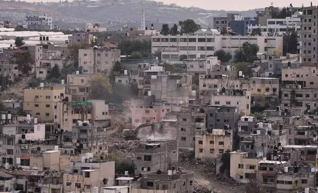 An Israeli army bulldozer demolishes homes in the Palestinian urban refugee camp of Nur Shams, near the West Bank city of Tulkarem, Wednesday, Dec. 31, 2025. (AP Photo/Majdi Mohammed)