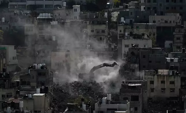 An Israeli army bulldozer demolishes homes in the Palestinian urban refugee camp of Nur Shams, near the West Bank city of Tulkarem, Wednesday, Dec. 31, 2025. (AP Photo/Majdi Mohammed)