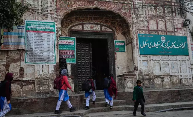 Students enter their school, set up in an old heritage building which was built during the Mughal era, in an old neighborhood of Lahore, Pakistan, Wednesday, Dec. 3, 2025. (AP Photo/K.M. Chaudary)