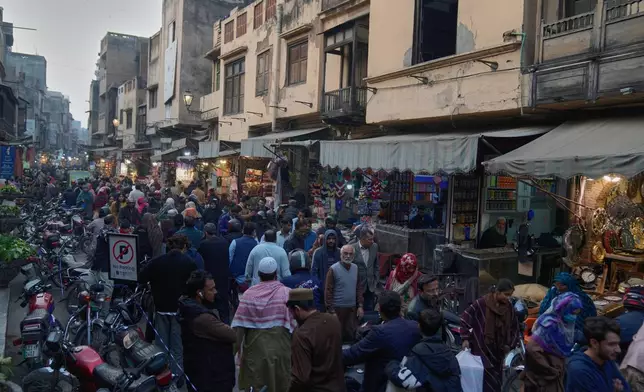 Local resident walks through a market it an old neighborhood of Lahore, Pakistan, Saturday, Dec. 6, 2025. (AP Photo/K.M. Chaudary)