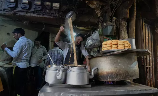 A vendor prepares traditional tea for his customers at a his tea stall in an old neighborhood of Lahore, Pakistan, Sunday, Dec. 7, 2025. (AP Photo/K.M. Chaudary)