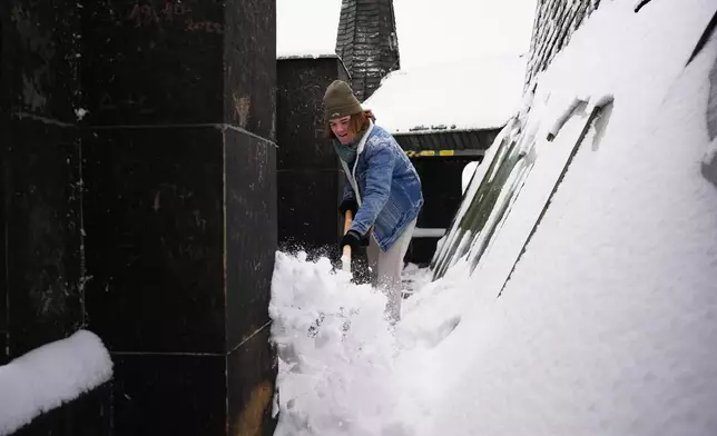 A man clears snow from a watch tower after a heavy snowfall in Prague, Czech Republic, Friday, Jan. 9, 2026. (AP Photo/Petr David Josek)