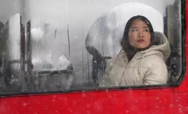 A woman looks through a fogged-up tram window during a snowfall in Belgrade, Serbia, Sunday, Jan. 4, 2026. (AP Photo/Darko Vojinovic)