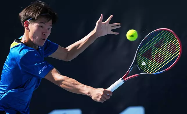 Michael Zheng of the U.S. plays a backhand return to Corentin Moutet of France during their second round match at the Australian Open tennis championship in Melbourne, Australia, Wednesday, Jan. 21, 2026. (AP Photo/Dar Yasin)