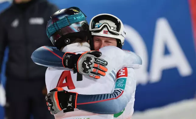 Norway's Atle Lie McGrath, second-placed in an alpine ski, men's World Cup slalom, back to camera, hugs winner Norway's Henrik Kristoffersen, in Schladming, Austria, Wednesday, Jan. 28, 2026. (AP Photo/Marco Trovati)