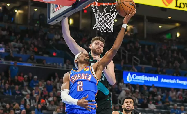 Oklahoma City Thunder guard Shai Gilgeous-Alexander, left, shoots in front of Portland Trail Blazers center Donovan Clingan during the second half of an NBA basketball game, Wednesday, Dec. 31, 2025, in Oklahoma City. (AP Photo/Kyle Phillips)