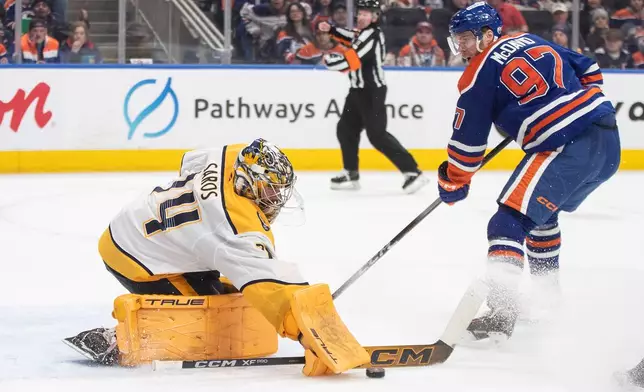 Nashville Predators goalie Juuse Saros (74) makes a save against Edmonton Oilers' Connor McDavid (97) during second period NHL action, in Edmonton, Alberta, on Tuesday, Jan. 6, 2026. (Jason Franson/The Canadian Press via AP)