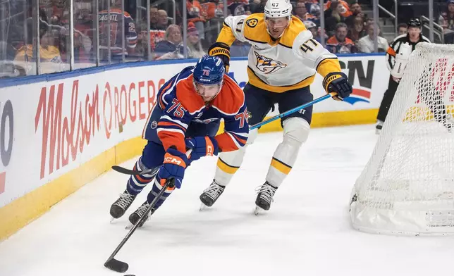 Nashville Predators' Michael McCarron (47) and Edmonton Oilers' Alec Regula (75) battle for the puck during second period NHL action, in Edmonton, Alberta, on Tuesday, Jan. 6, 2026. THE CANADIAN PRESS/Jason Franson/The Canadian Press via AP)