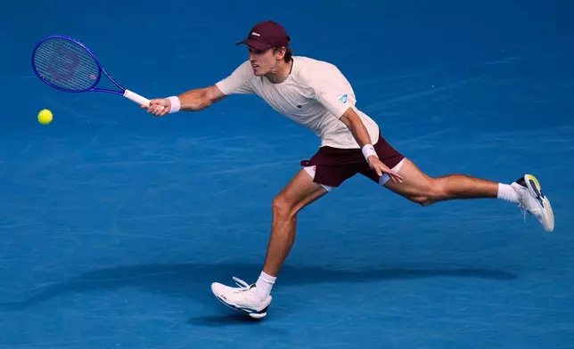 Alex de Minaur of Australia plays a forehand return to Mackenzie McDonald of the U.S. during their first round match at the Australian Open tennis championship in Melbourne, Australia, Monday, Jan. 19, 2026. (AP Photo/Aaron Favila)