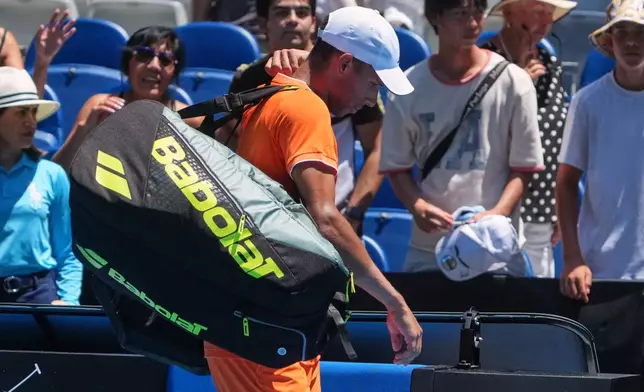Felix Auger-Aliassime of Canada walks from the court after he retired in his first round match against Nuno Borges of Portugal at the Australian Open tennis championship in Melbourne, Australia, Monday, Jan. 19, 2026. (AP Photo/Asanka Brendon Ratnayake)
