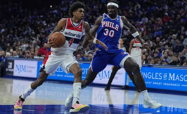 Washington Wizards' AJ Johnson (4) tries to get a shot past during the first half of an NBA basketball game Wednesday, Jan. 7, 2026, in Philadelphia. (AP Photo/Matt Rourke)