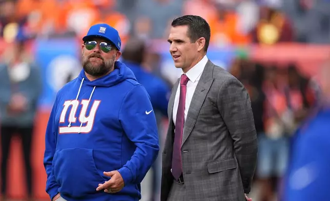 New York Giants head coach Brian Daboll, left, confers with general manager Joe Schoen before an NFL football game Sunday, Oct. 19, 2025, in Denver. (AP Photo/David Zalubowski)