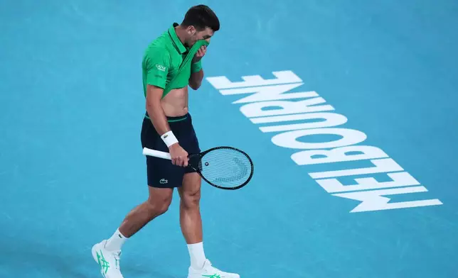 Novak Djokovic of Serbia wipes the sweat from his face during his first round match against Pedro Martinez of Spain at the Australian Open tennis championship in Melbourne, Australia, Monday, Jan. 19, 2026. (AP Photo/Aaron Favila)