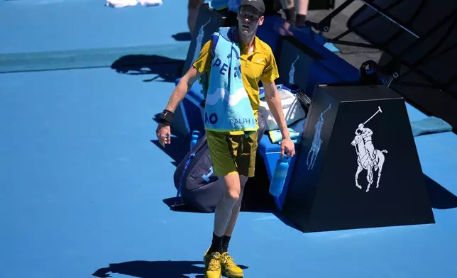 Jannik Sinner of Italy walks from the court as play is halted due to extreme heat during his third round match against Eliot Spizzirri of the U.S. at the Australian Open tennis championship in Melbourne, Australia, Saturday, Jan. 24, 2026. (AP Photo/Dita Alangkara)