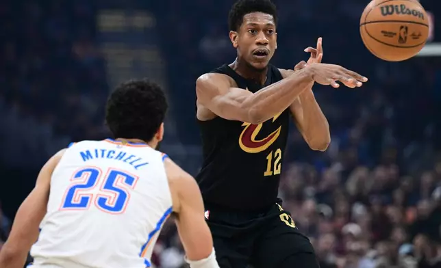 Cleveland Cavaliers forward De'andre Hunter, right, passes the ball against Oklahoma City Thunder guard Ajay Mitchell, left, in the first half of an NBA basketball game, Monday, Jan. 19, 2026, in Cleveland. (AP Photo/David Dermer)