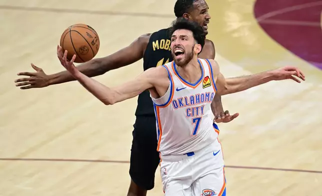 Oklahoma City Thunder center Chet Holmgren (7) spins to the basket while being fouled by Cleveland Cavaliers center Evan Mobley, back, Monday, Jan. 19, 2026, in Cleveland. (AP Photo/David Dermer)