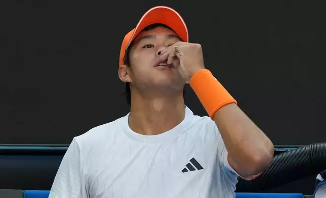 Learner Tien of the U.S. attempts to stop a nose bleed during his fourth round match against Daniil Medvedev of Russia at the Australian Open tennis championship in Melbourne, Australia, Sunday, Jan. 25, 2026. (AP Photo/Asanka Brendon Ratnayake)