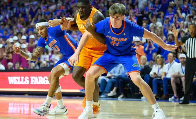 Florida forward Alex Condon (21) and guard Isaiah Brown (20) box out against Tennessee forward DeWayne Brown II (6) during the first half of an NCAA college basketball game, Saturday, Jan. 10, 2026, in Gainesville, Fla. (AP Photo/Noah Lantor)