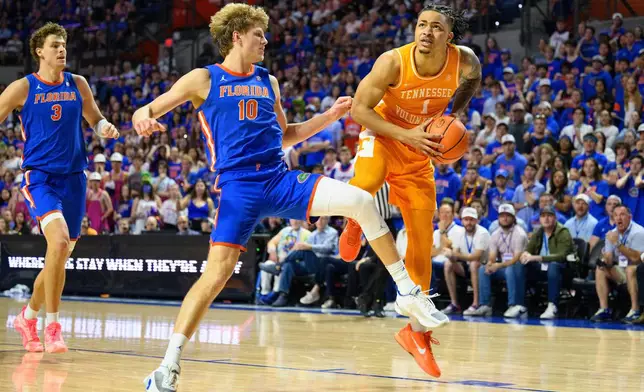 Tennessee guard Amari Evans (1) drives on Florida forward Thomas Haugh (10) during the first half of an NCAA college basketball game, Saturday, Jan. 10, 2026, in Gainesville, Fla. (AP Photo/Noah Lantor)