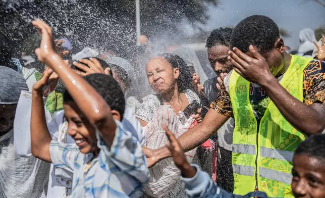 Holy water is sprayed on Ethiopian Orthodox worshippers, during the celebration of the Ethiopian Epiphany on lake Dembel, in Batu, Ethiopia, Monday, Jan. 19, 2026. (AP Photo/Amanuel Sileshi)