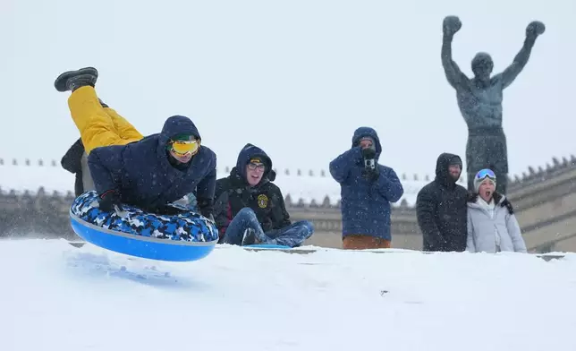 People sled at Philadelphia Art Museum steps by the Rocky statue during a winter storm in Philadelphia, Sunday, Jan. 25, 2026. (AP Photo/Matt Rourke)