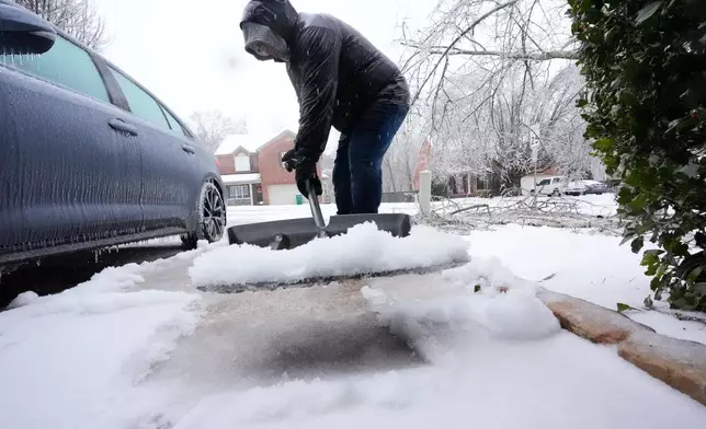 David Bentley shovels ice and snow from his driveway during a winter storm Sunday, Jan. 25, 2026, in Nashville, Tenn. (AP Photo/George Walker IV)