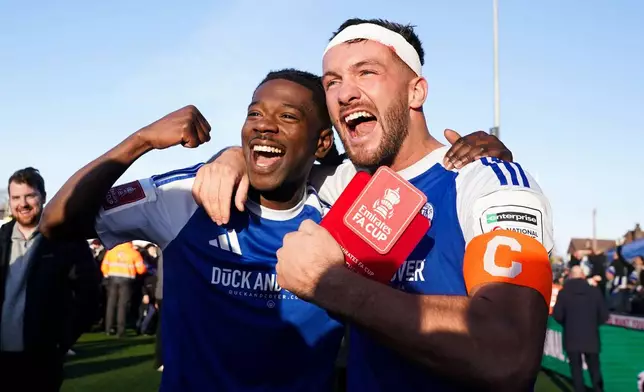 Macclesfield FC goalscorers Paul Dawson, right and Isaac Buckley-Ricketts celebrate following the FA Cup third round soccer match between Macclesfield Town and Crystal Palace, at the Leasing.com Stadium, Macclesfield, England, Saturday, Jan. 10, 2026. (Martin Rickett/PA via AP)