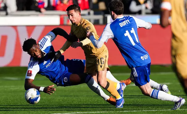 Crystal Palace's Yeremi Pino and Macclesfield Town's Rollin Menayese vie for the ball, during the FA Cup third round soccer match between Macclesfield Town and Crystal Palace, at the Leasing.com Stadium, Macclesfield, England, Saturday, Jan. 10, 2026. (Martin Rickett/PA via AP)