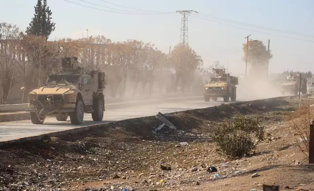 U.S. military vehicles from the U.S.-led coalition against the Islamic State group drive through Deir Hafer, Syria, Friday, Jan. 16, 2026, before a meeting with the U.S.-backed Syrian Democratic Forces. (AP Photo/Baderkhan Ahmad)
