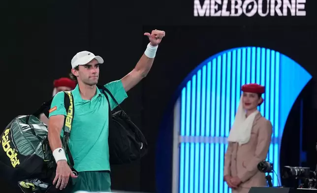 Eliot Spizzirri of the U.S. waves as he leaves the court following his third round loss to Jannik Sinner of Italy at the Australian Open tennis championship in Melbourne, Australia, Saturday, Jan. 24, 2026. (AP Photo/Dita Alangkara)