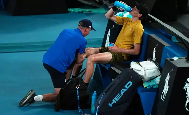 Jannik Sinner of Italy receives treatment from a trainer during his third round match against Eliot Spizzirri of the U.S. at the Australian Open tennis championship in Melbourne, Australia, Saturday, Jan. 24, 2026. (AP Photo/Dar Yasin)