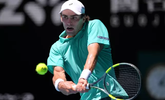 Eliot Spizzirri of the U.S. plays a backhand return to Jannik Sinner of Italy during their third round match at the Australian Open tennis championship in Melbourne, Australia, Saturday, Jan. 24, 2026. (AP Photo/Dita Alangkara)