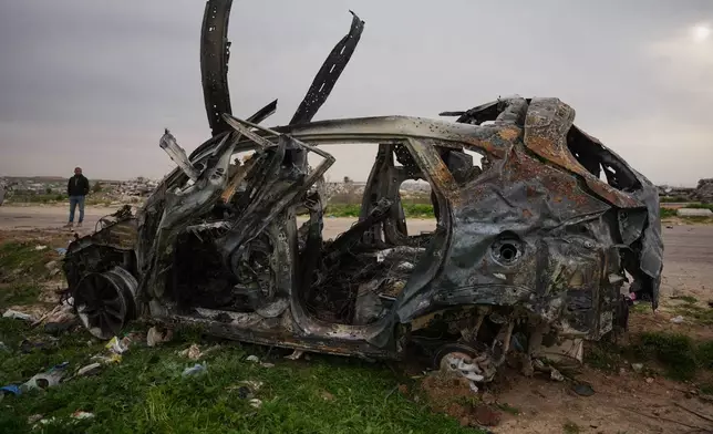 A man stands next to an Egyptian committee's vehicle that was hit by an Israeli strike, killing three Palestinian journalists, in Zahraa, central Gaza Strip, Wednesday, Jan. 21, 2026. (AP Photo/Abdel Kareem Hana)