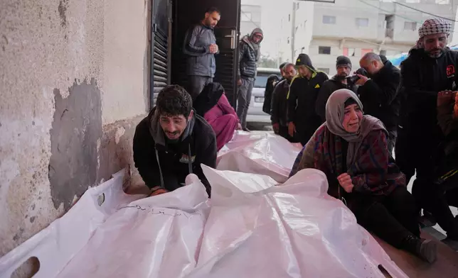 Najwa Al-Rajoudi, right, mourns over the body of her nephew Moussa Al-Rajoudi during his funeral at Al-Aqsa Hospital in Deir al-Balah, central Gaza Strip, Wednesday, Jan. 21, 2026, after he was killed in an Israeli fire. (AP Photo/Abdel Kareem Hana)