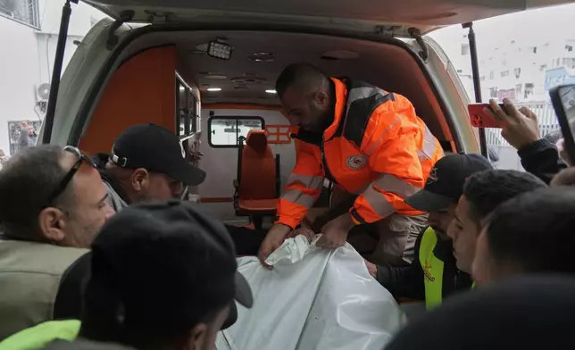 People carry a bag containing the bodies of the Palestinian journalists Abd Shaat and Mohamed Qeshta, who were killed in an Israeli strike on a vehicle, before their funeral at Shifa Hospital, in Gaza City, Wednesday, Jan. 21, 2026. (AP Photo/Jehad Alshrafi)