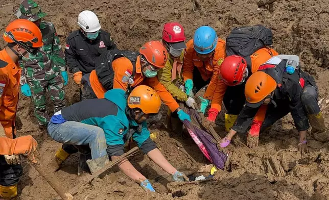 In this photo released by the Indonesian National Search and Rescue Agency (BASARNAS), rescuers search for victims in Pasir Langu village after a landslide, in West Bandung district of West Java province, Indonesia, Sunday, Jan. 25, 2026. (BASARNAS via AP)