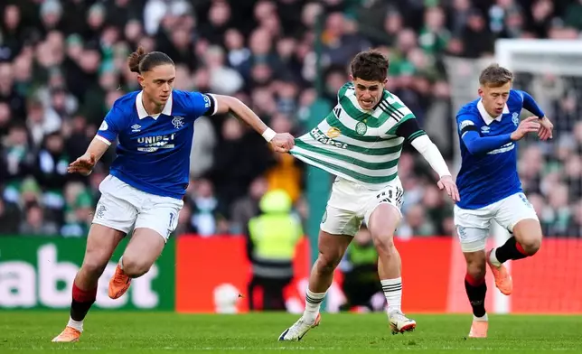 Rangers' Thelo Aasgaard, left, pulls back on Celtic's Luke McCowan during the Scottish Premiership soccer match between Celtic and Rangers in Glasgow, Scotland, Saturday, Jan. 3, 2026. (Andrew Milligan/PA via AP)